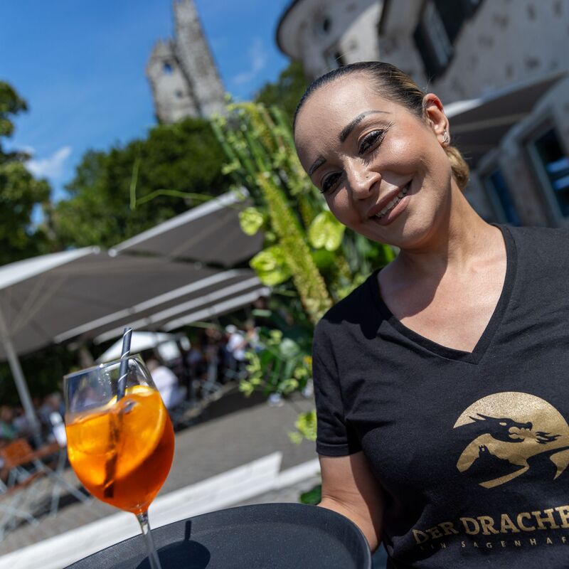 Kellnerin serviert einen Aperol Spritz