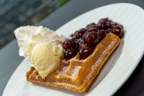 Waffel mit Puderzucker und heißen Kirschen